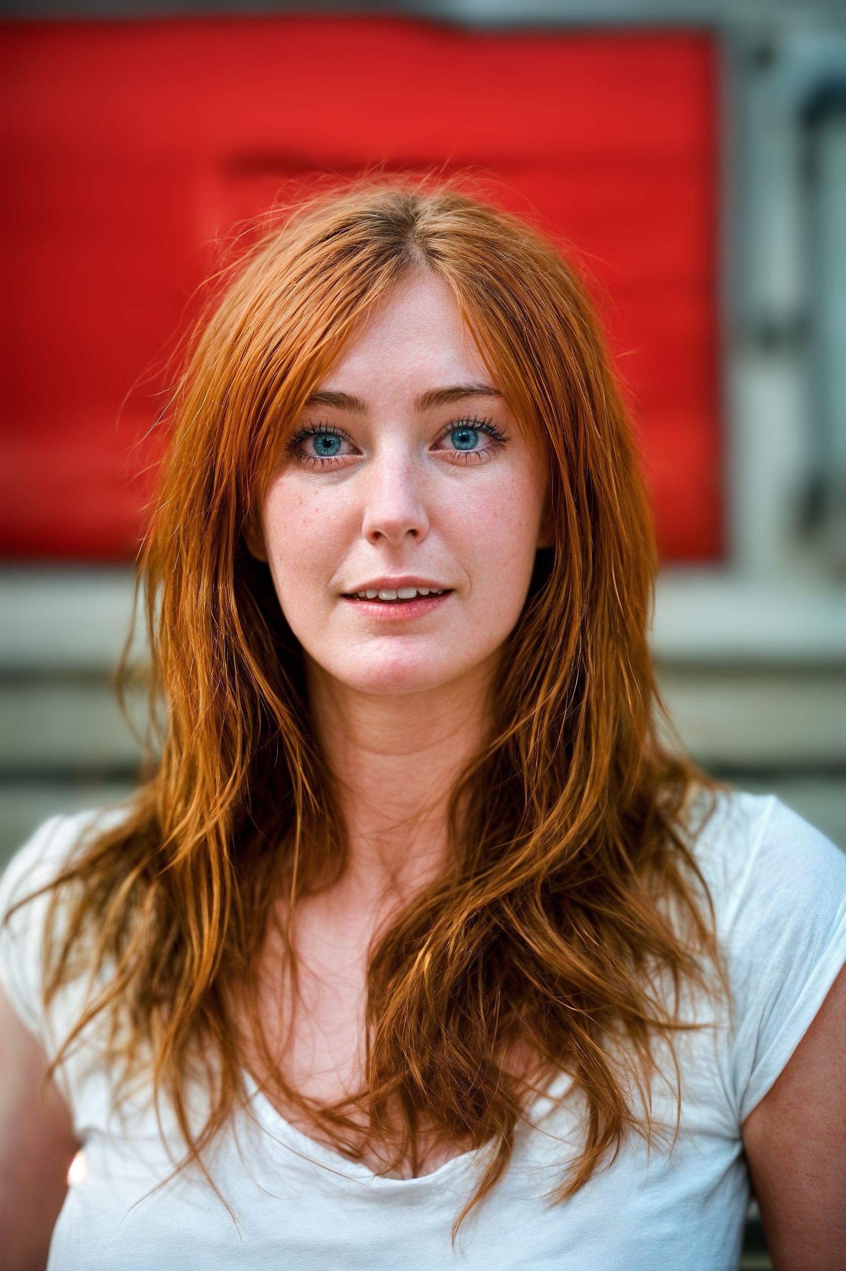 a woman with long red hair and blue eyes