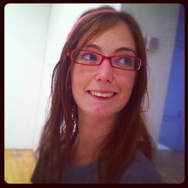 a woman with glasses and a pink headband