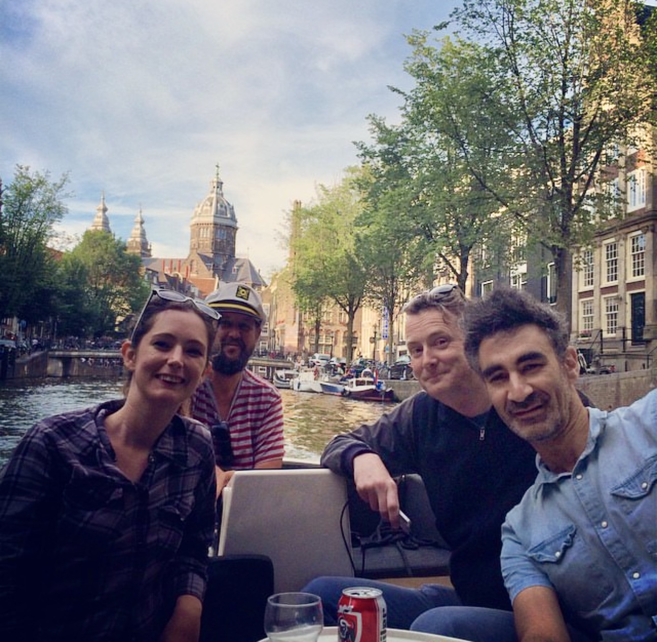 three people sitting on a boat in the water