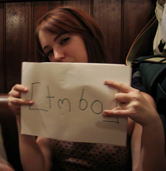 a woman holding up a piece of paper with the word love written on it