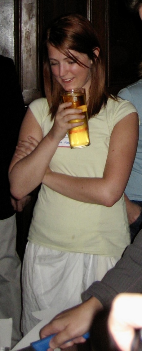 a woman sitting on a couch holding a glass of beer