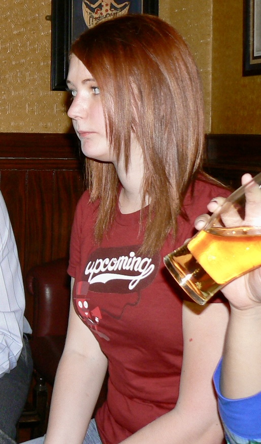 a woman sitting on a couch holding a beer