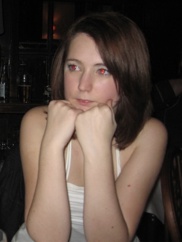 a woman sitting at a table with her hand on her chin