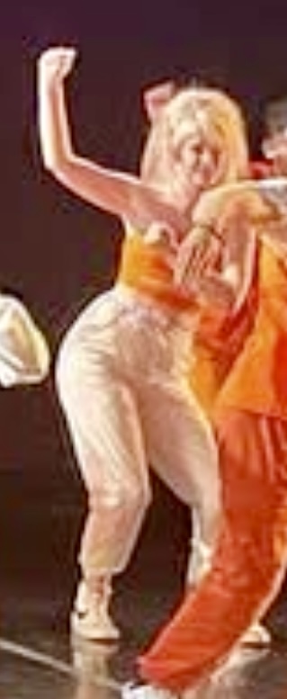 a group of dancers in orange outfits