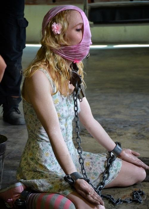 a woman in a pink scarf sitting on the ground