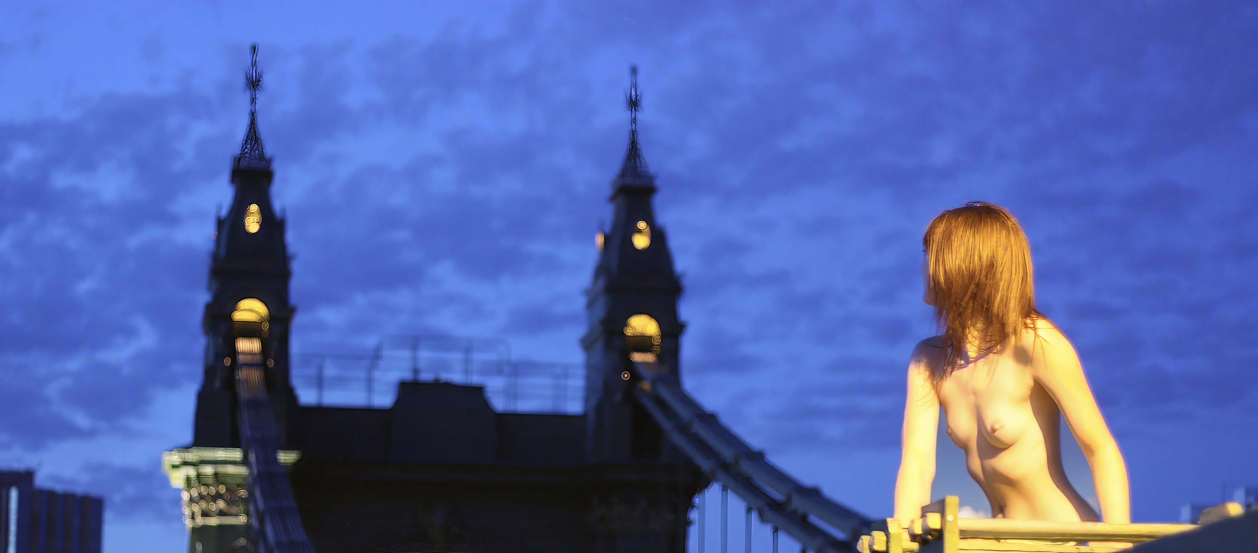 a woman sitting on a bench in front of a clock tower