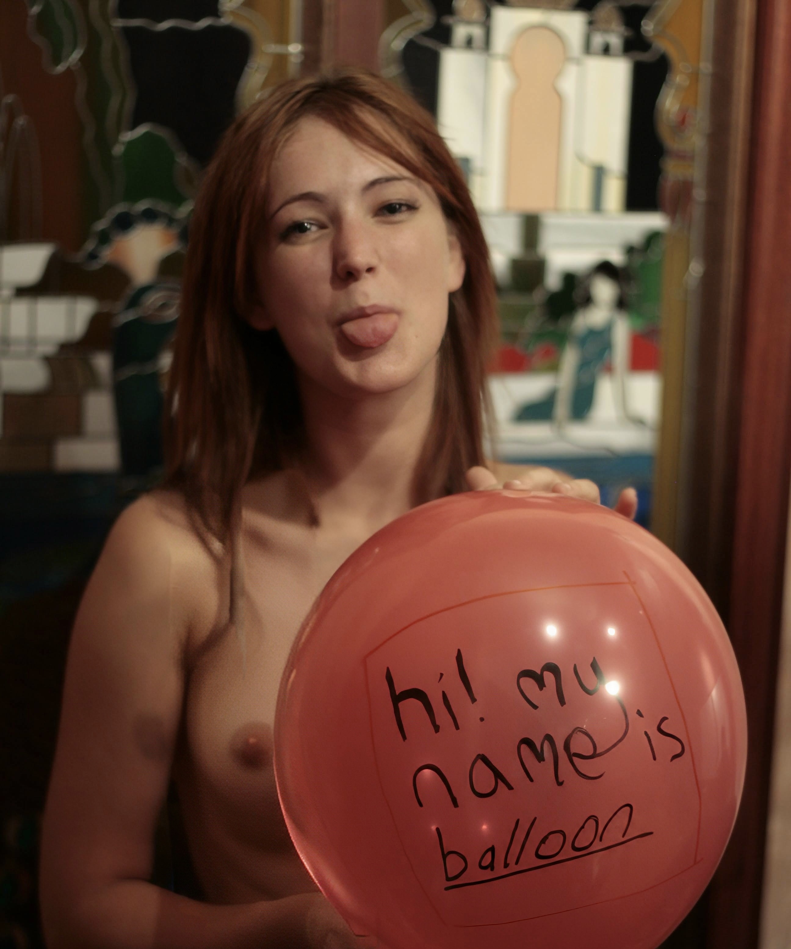 a woman holding a balloon with a sign on it