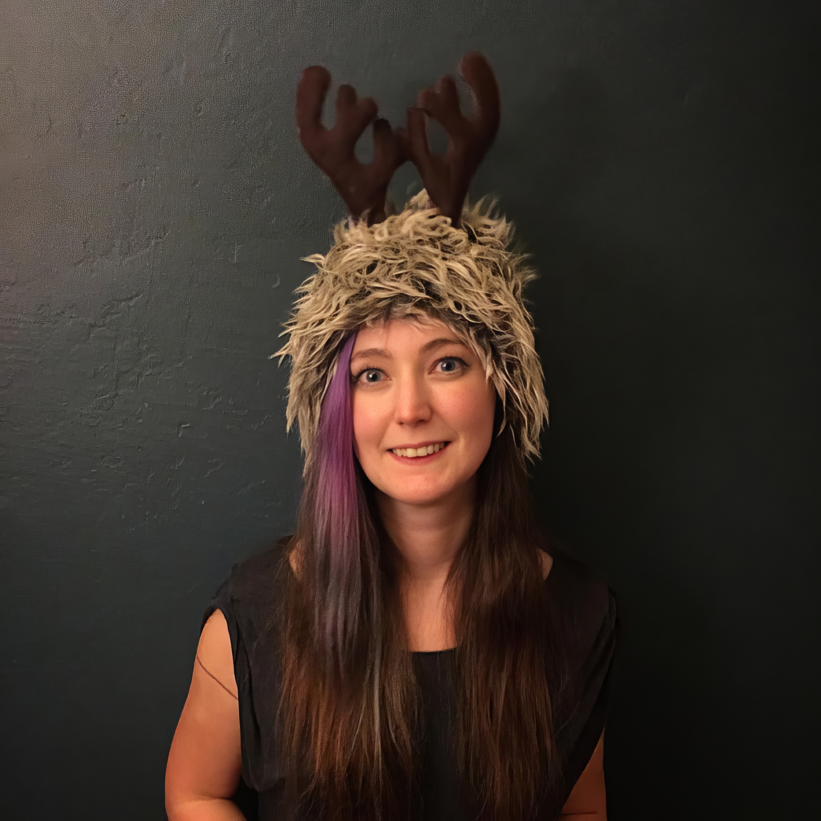 a woman wearing a reindeer hat with ant inal peal ae,
TEs ot saree
Be sags