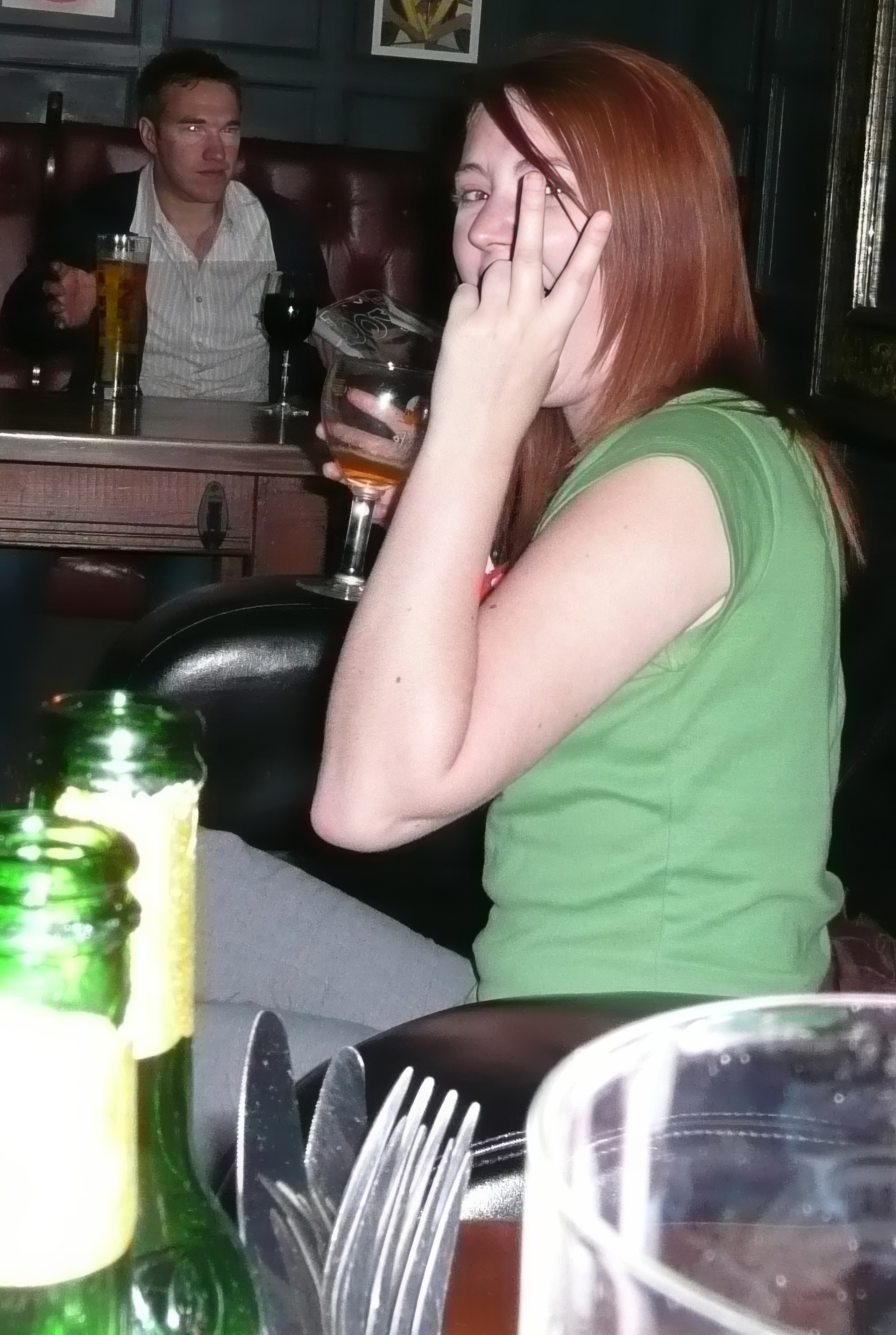 a woman sitting at a table with a cellphone phone :
¥
S