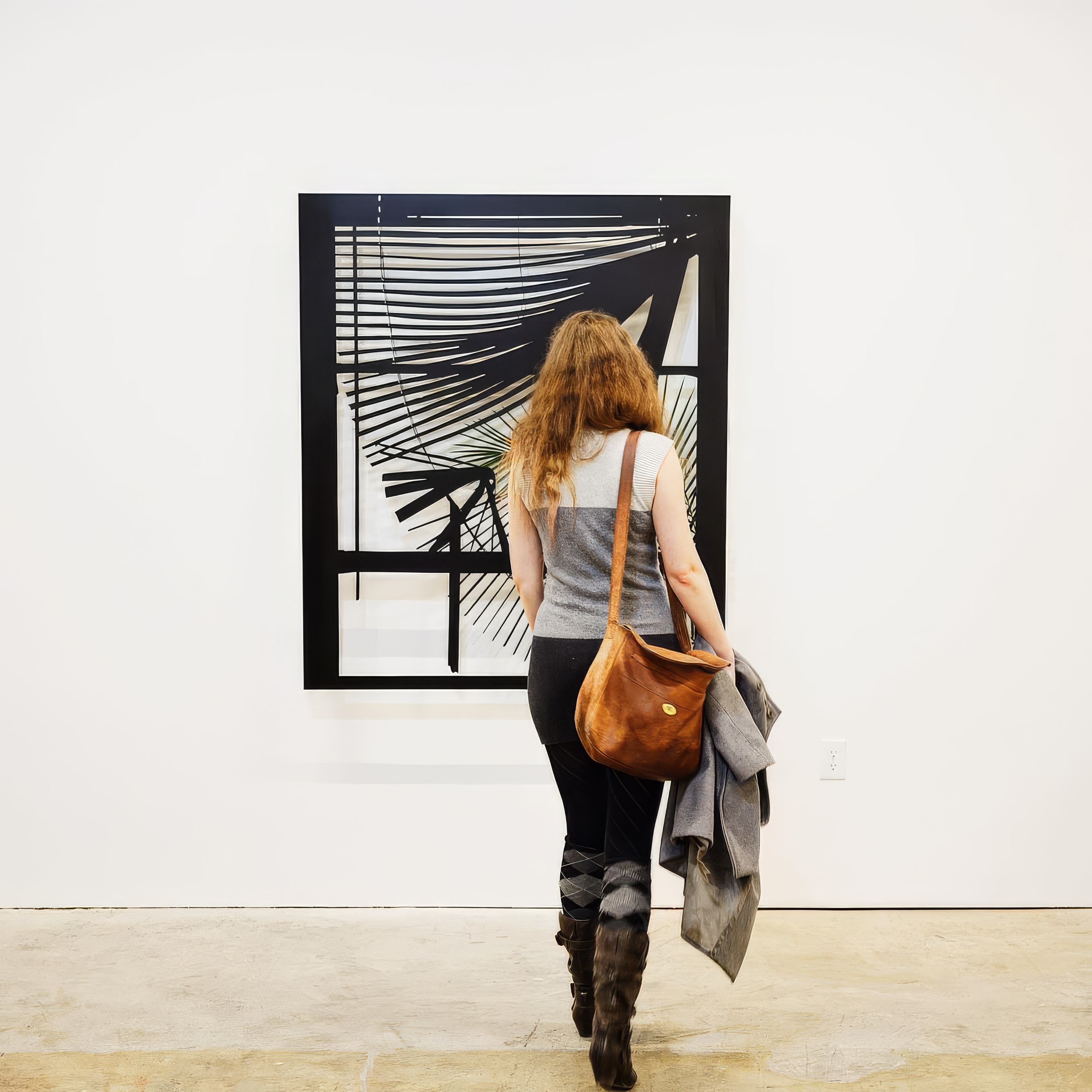 a woman is walking in front of a painting