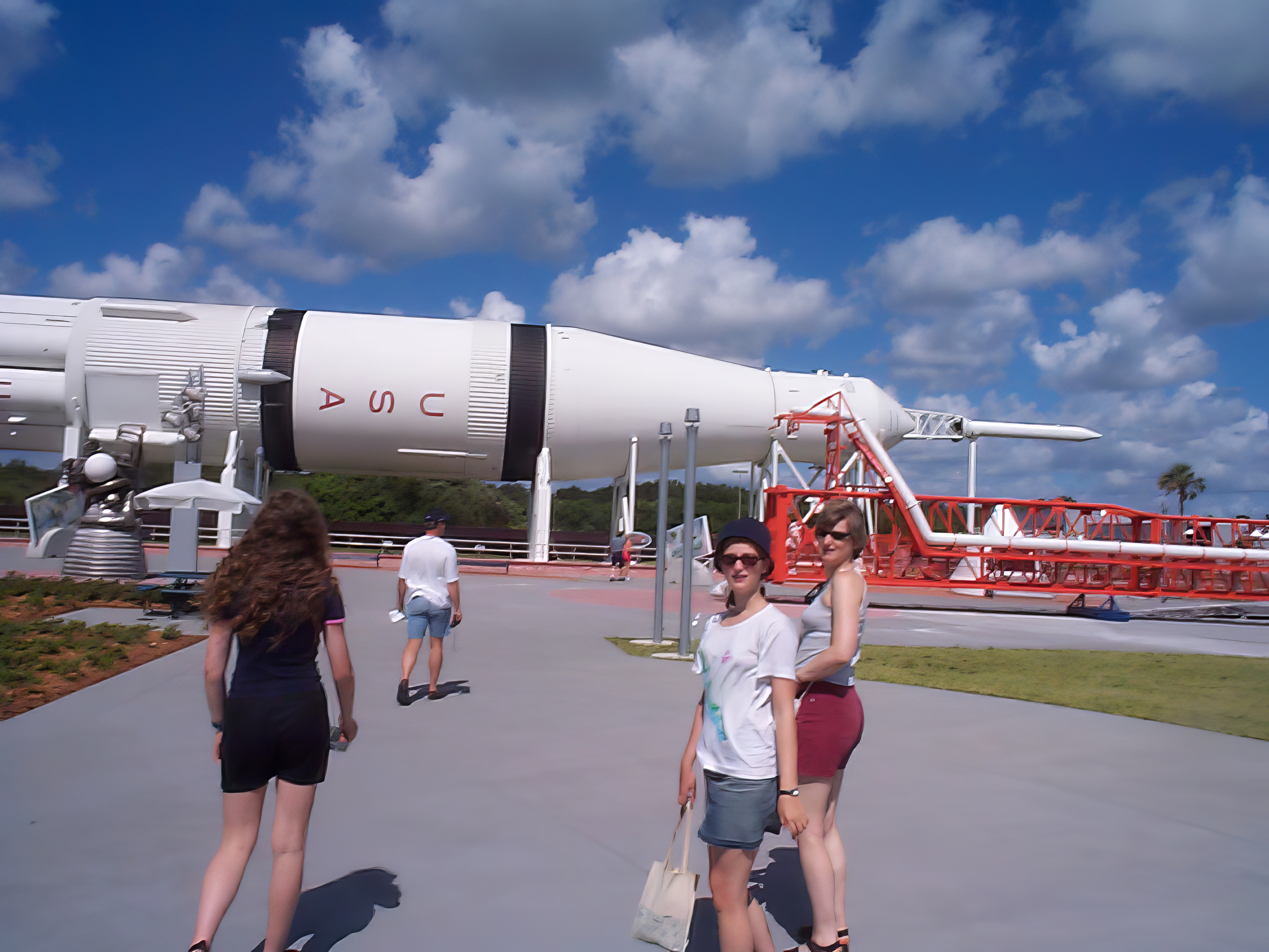 a group of people walking around a large white plane l

Sates