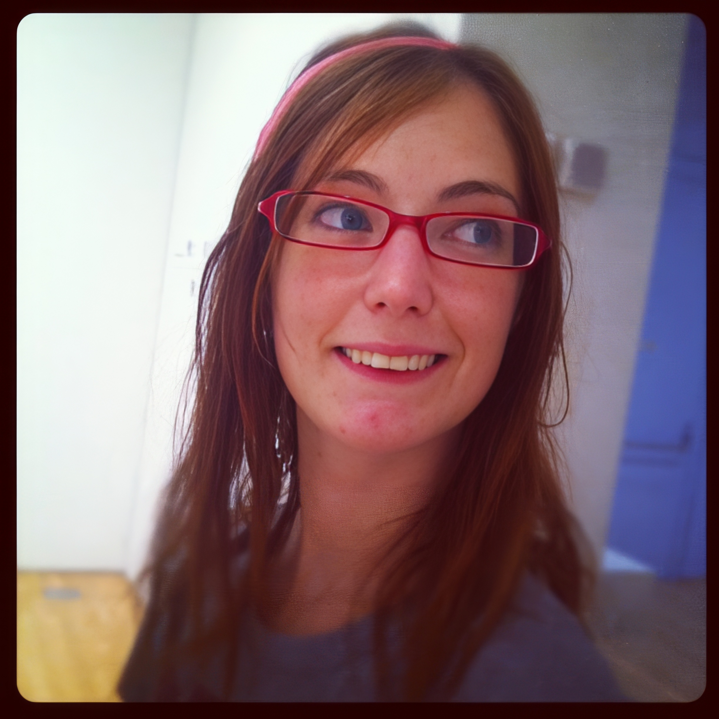 a woman with glasses and a pink headband