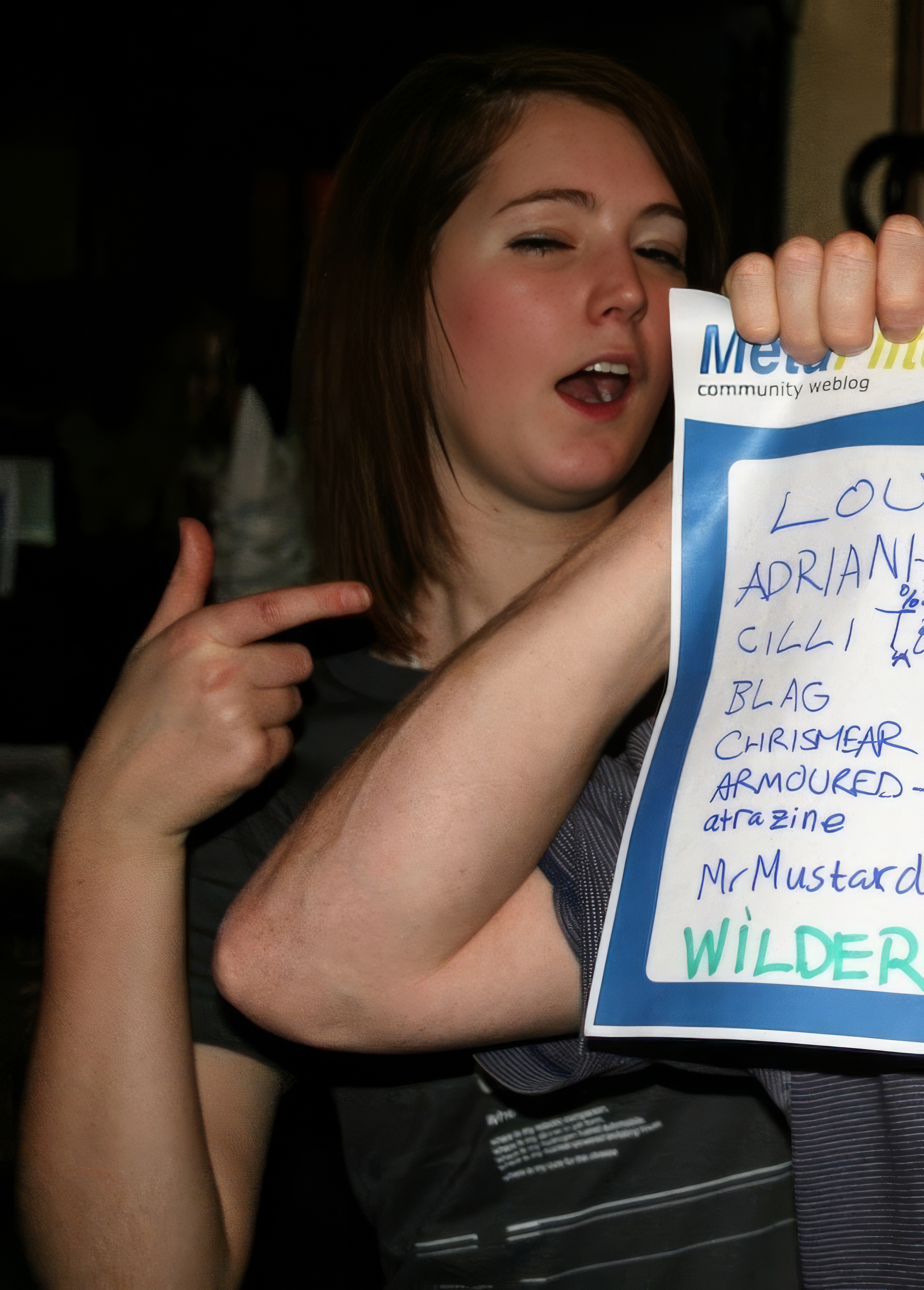 a woman holding a sign with a note attached to it