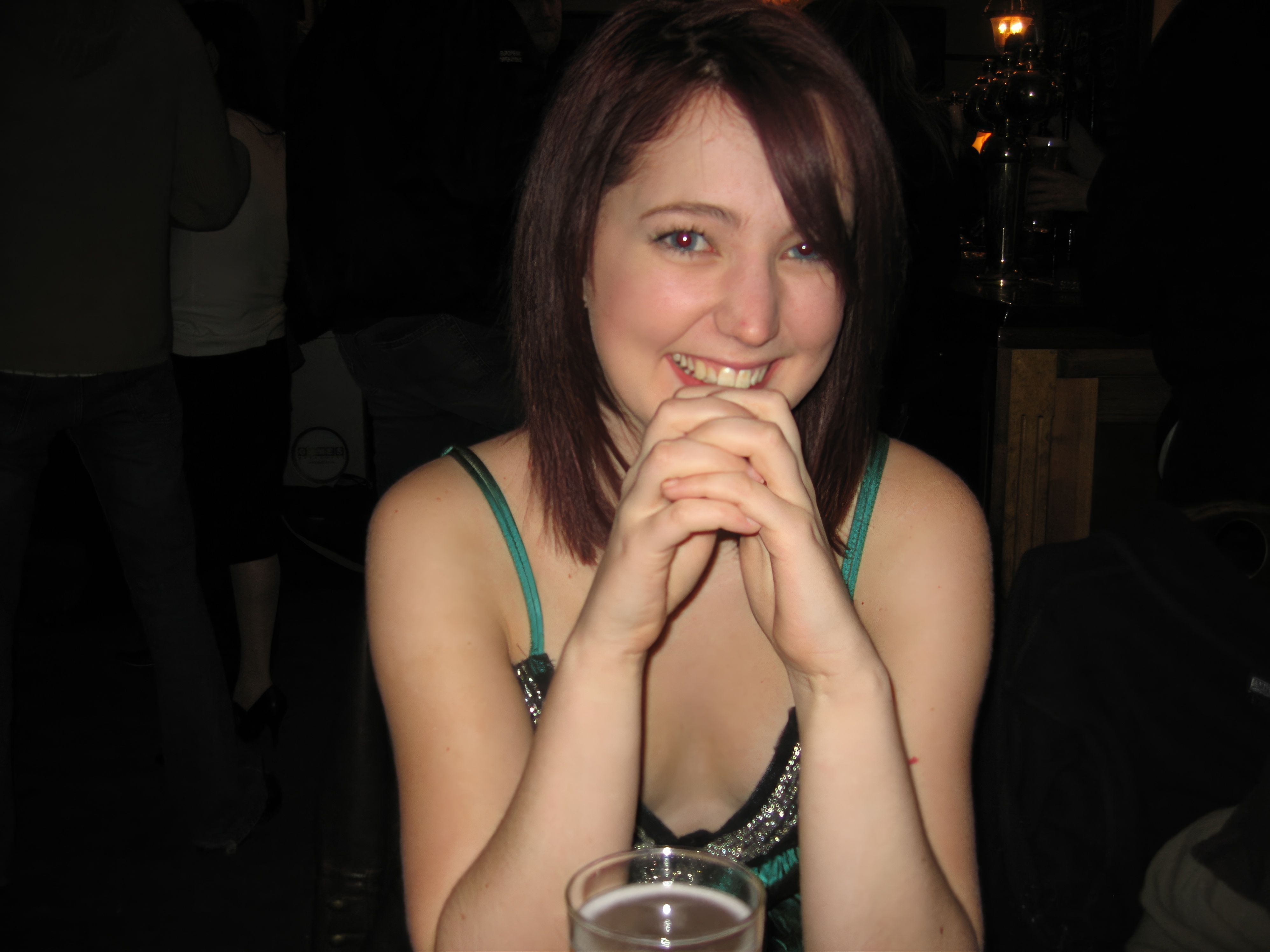 a woman sitting at a table with a glass of wine