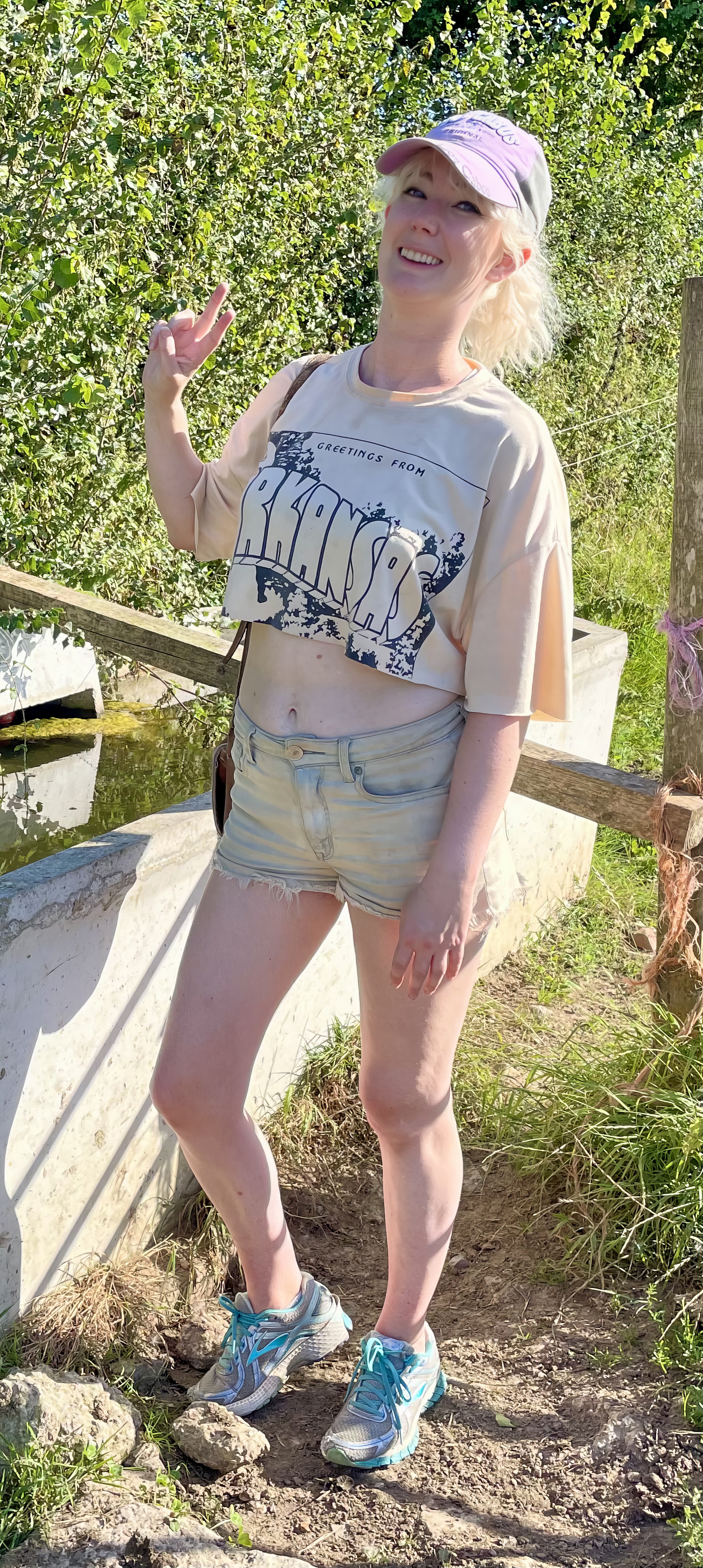 a little girl standing in the dirt near a boat