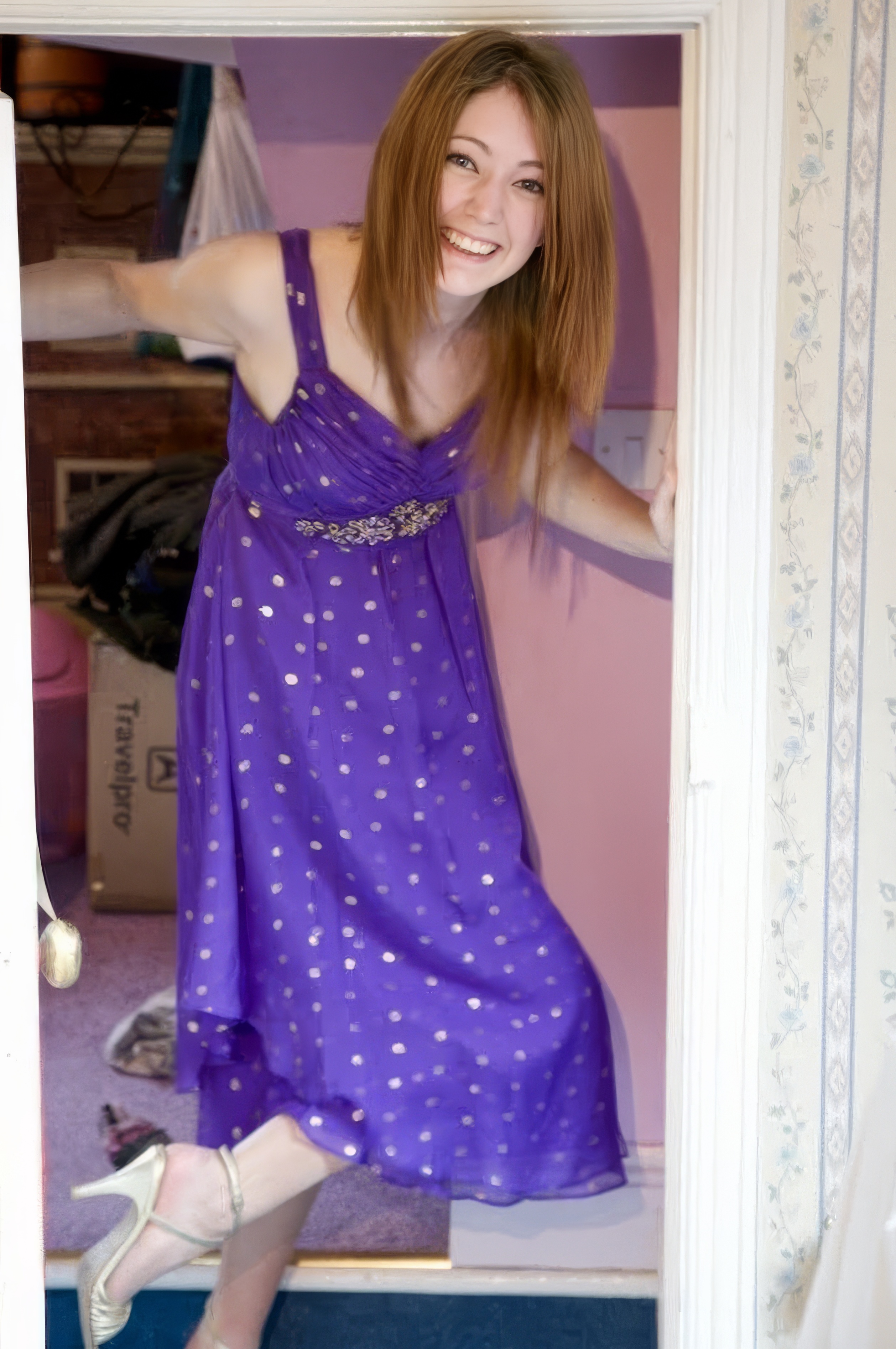 a woman in a purple dress is standing in a doorway