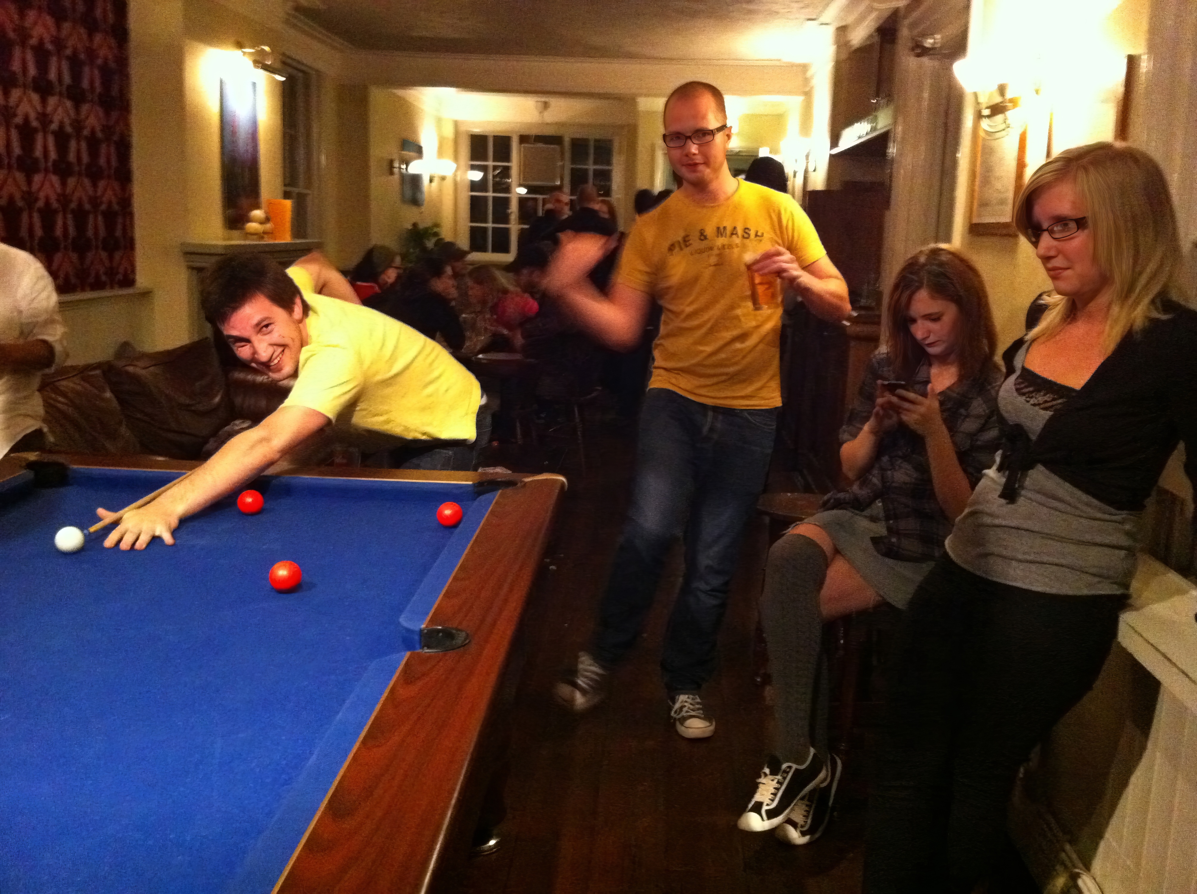 a group of people playing a game of pool