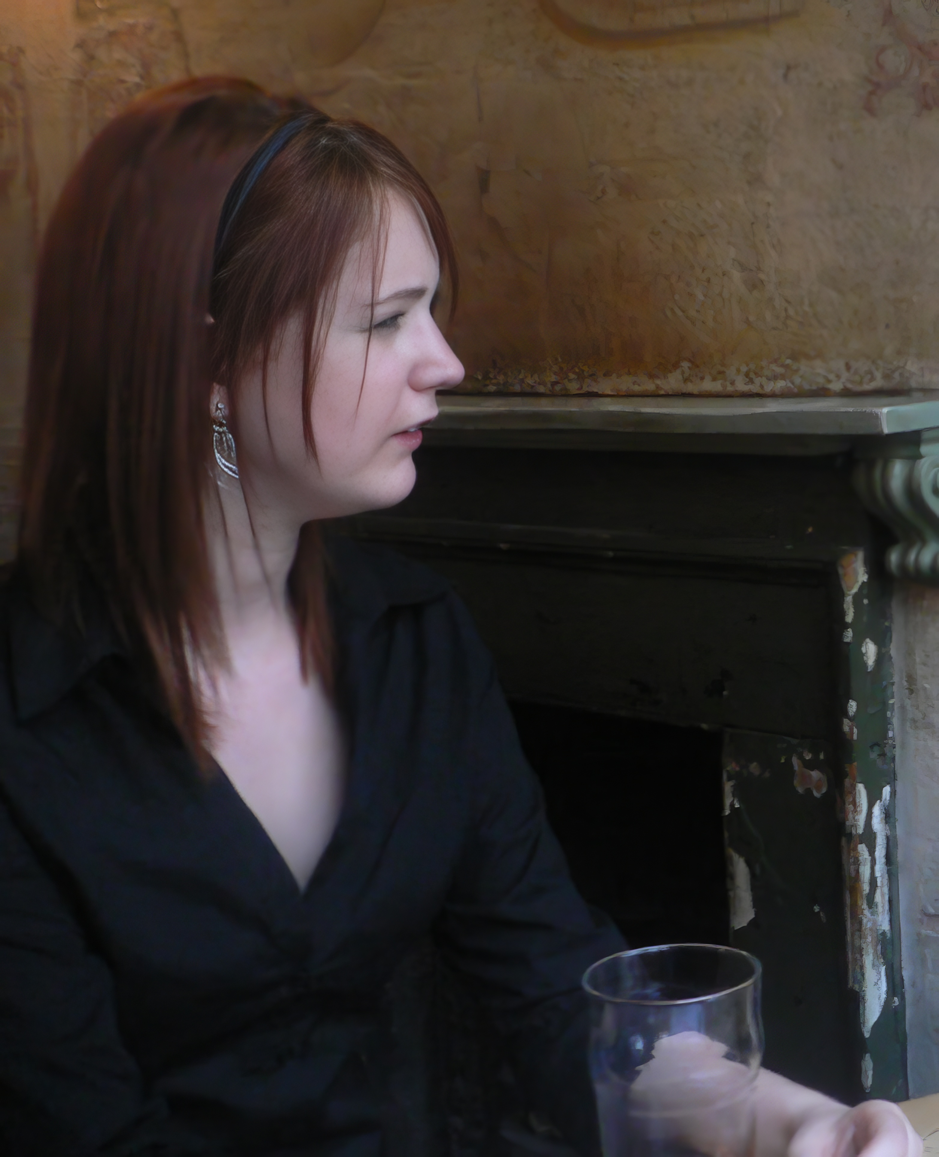 a woman sitting in front of a fireplace