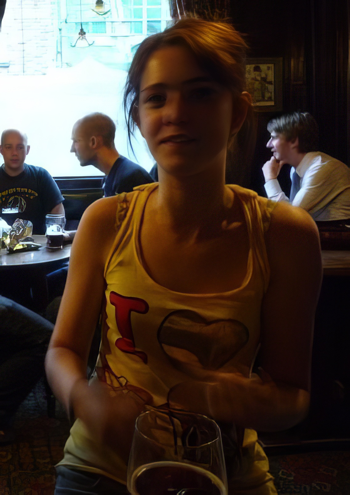 a woman sitting in a restaurant with a glass of wine