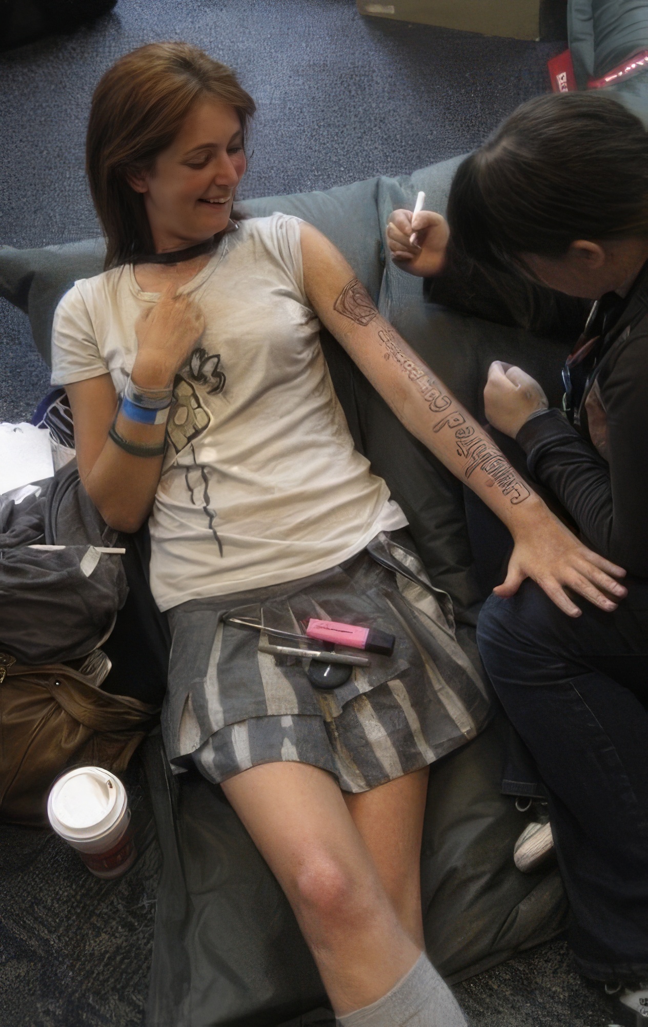 a woman sitting on a couch with a tattoo on her arm