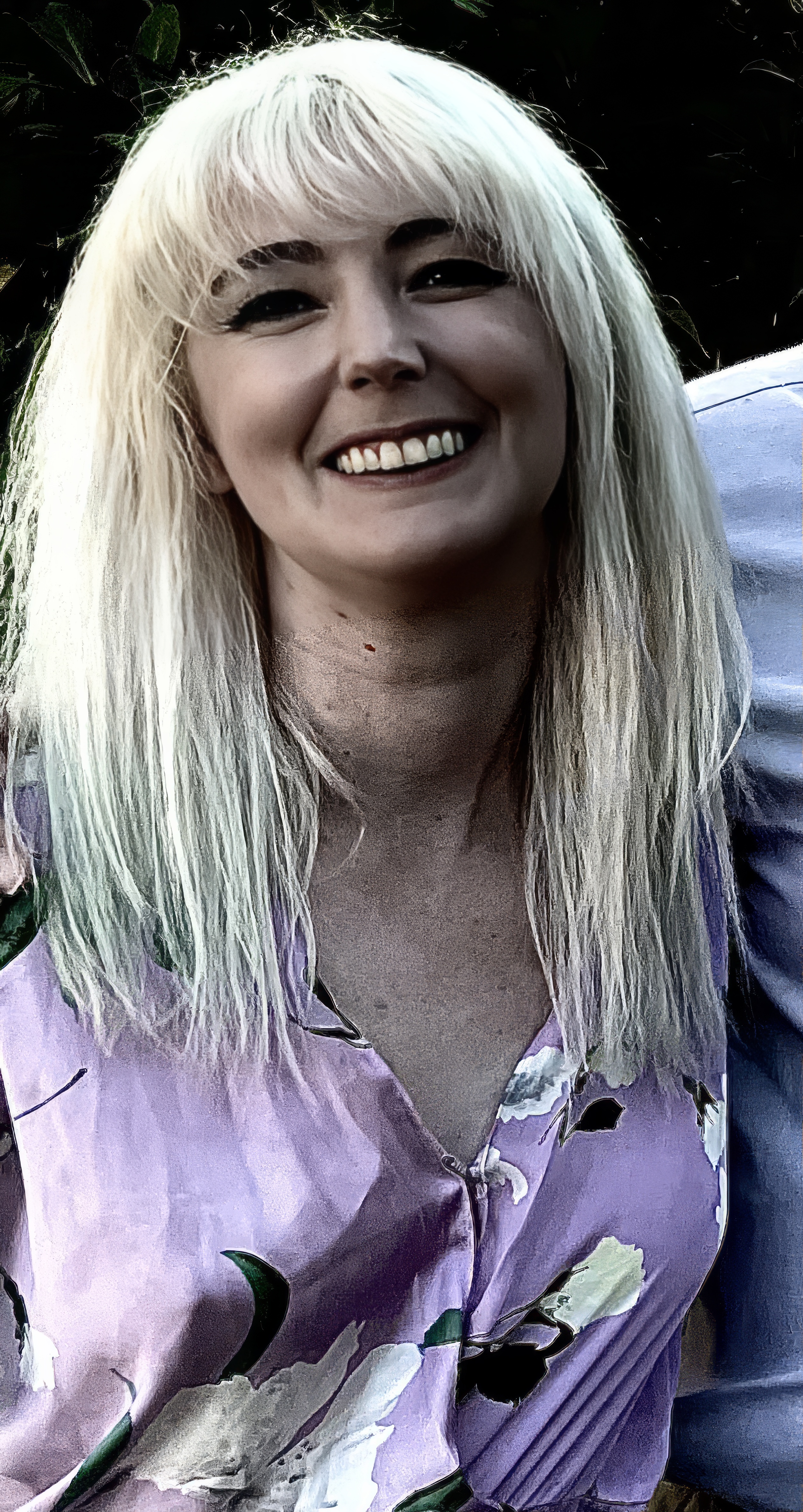 a woman with blonde hair and a purple shirt