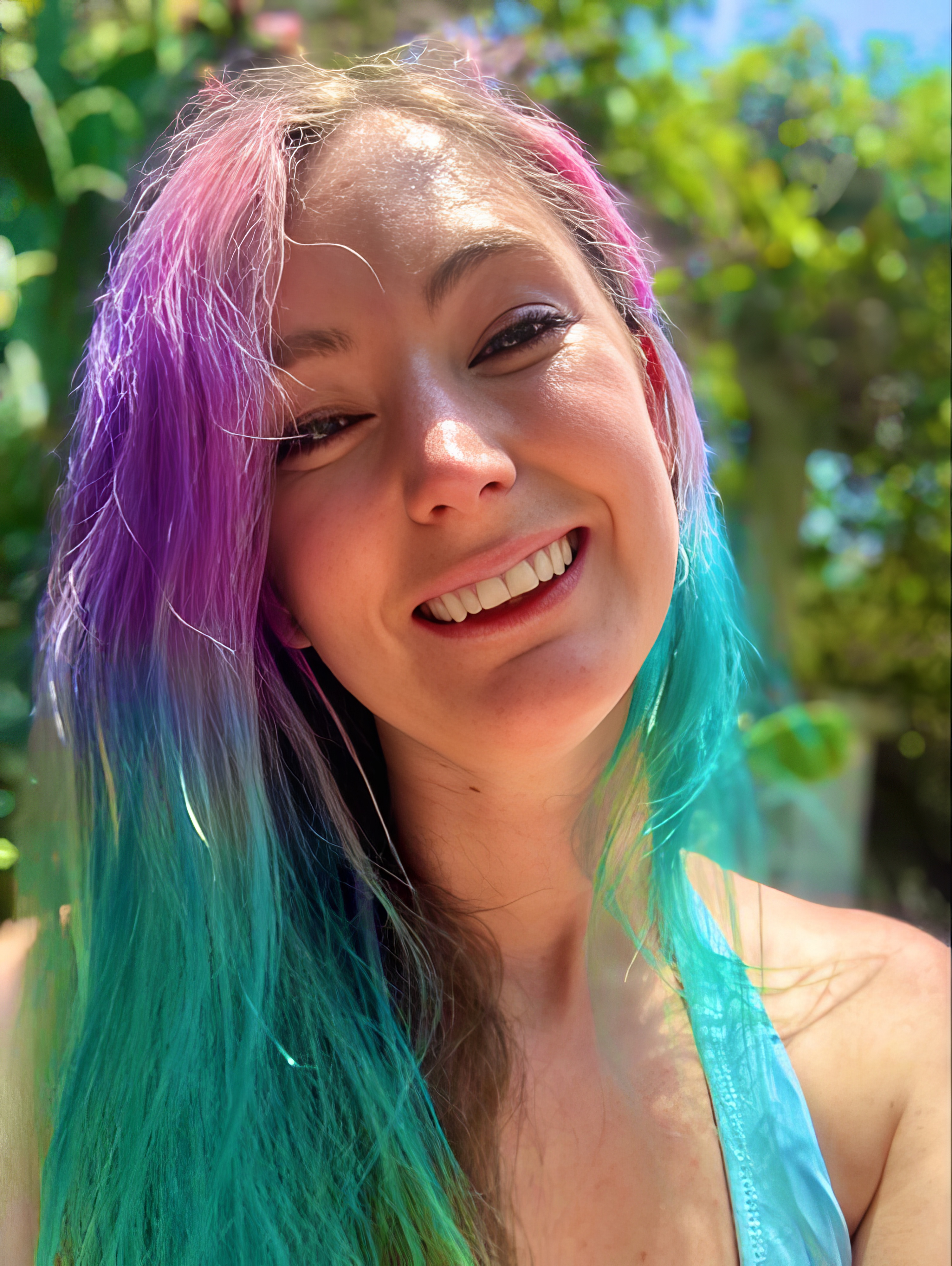 a woman with a colorful hair and a blue tank top