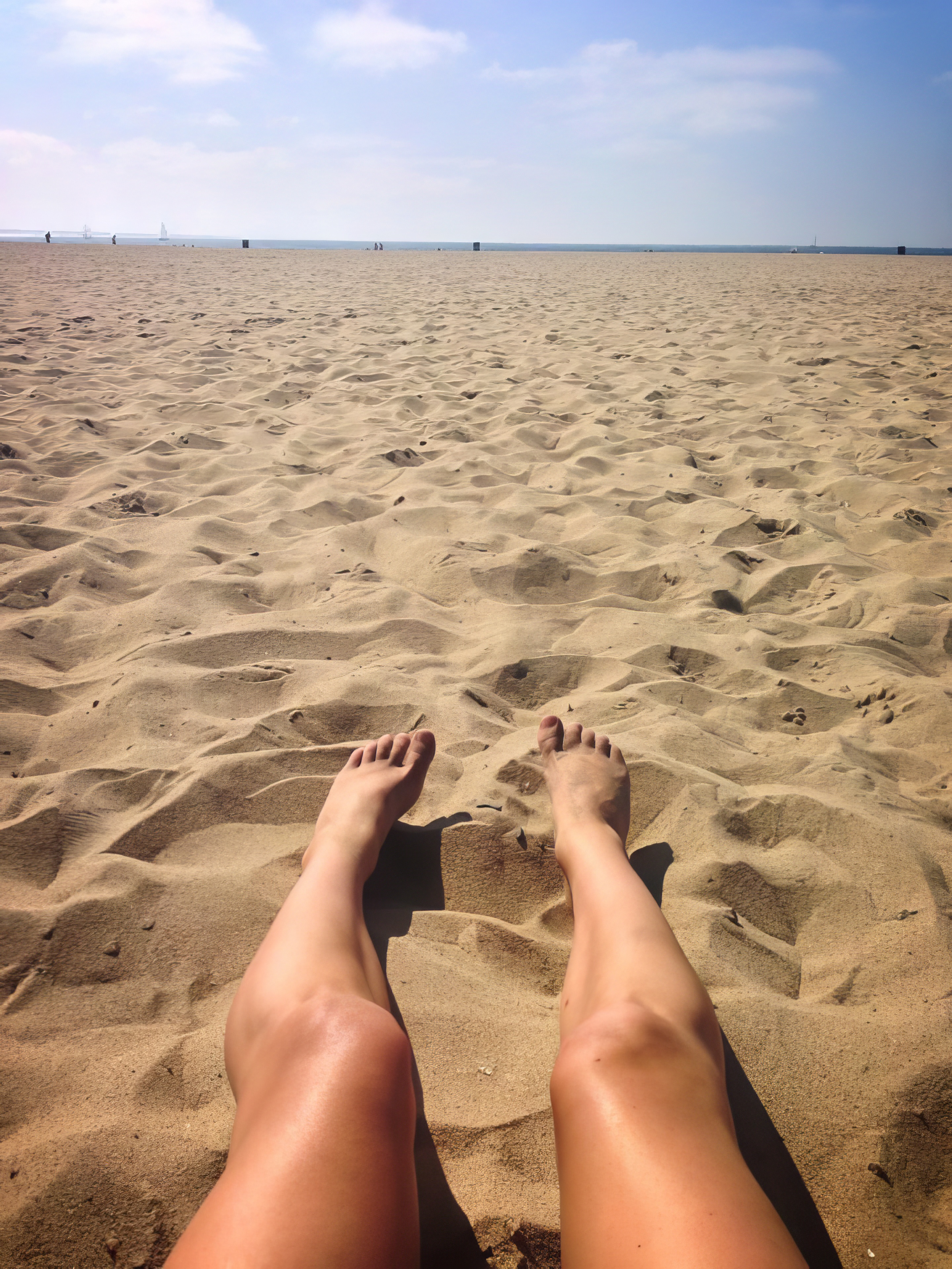 a person's feet in the sand on a beach