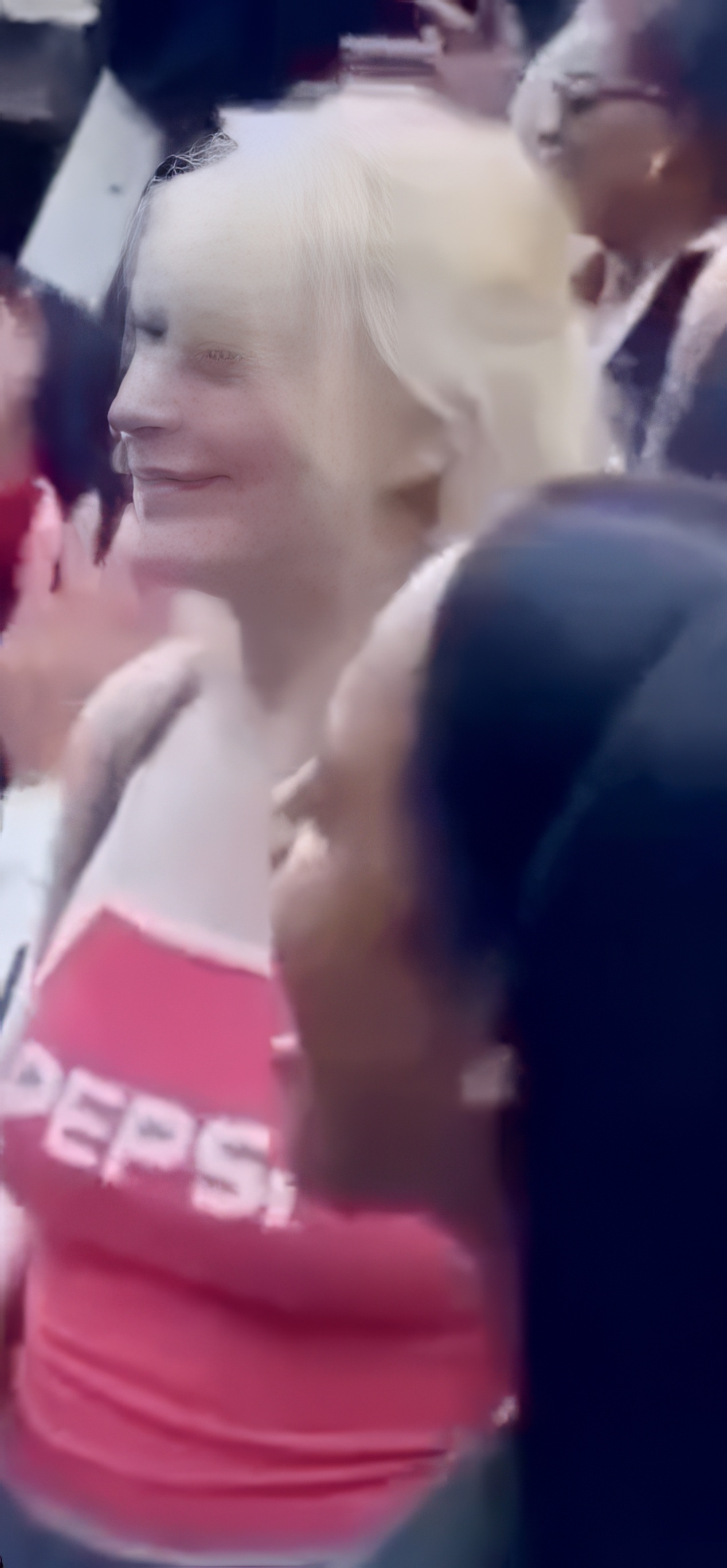 a woman in a red shirt is surrounded by a crowd