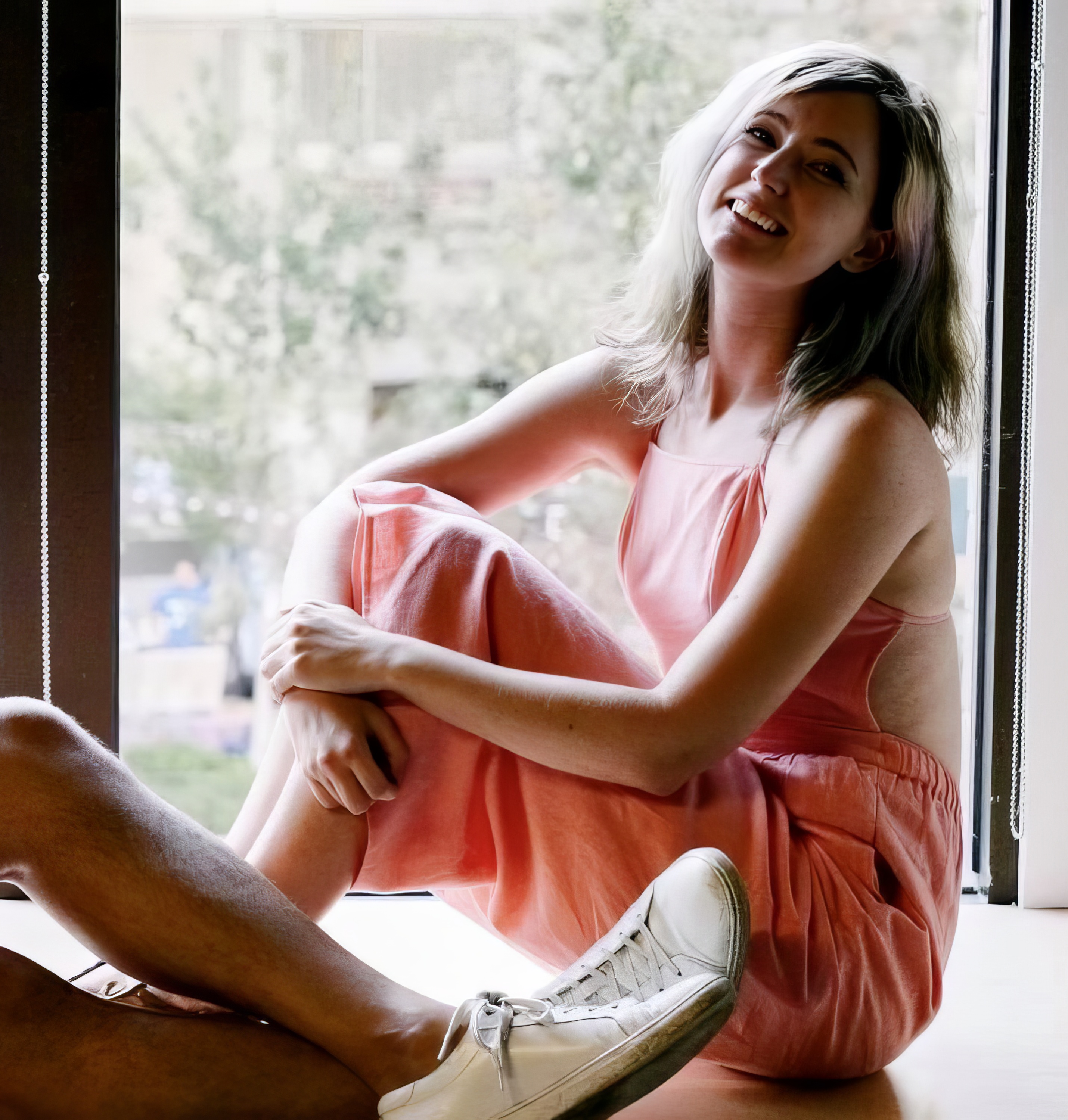 a woman sitting on the floor in front of a window