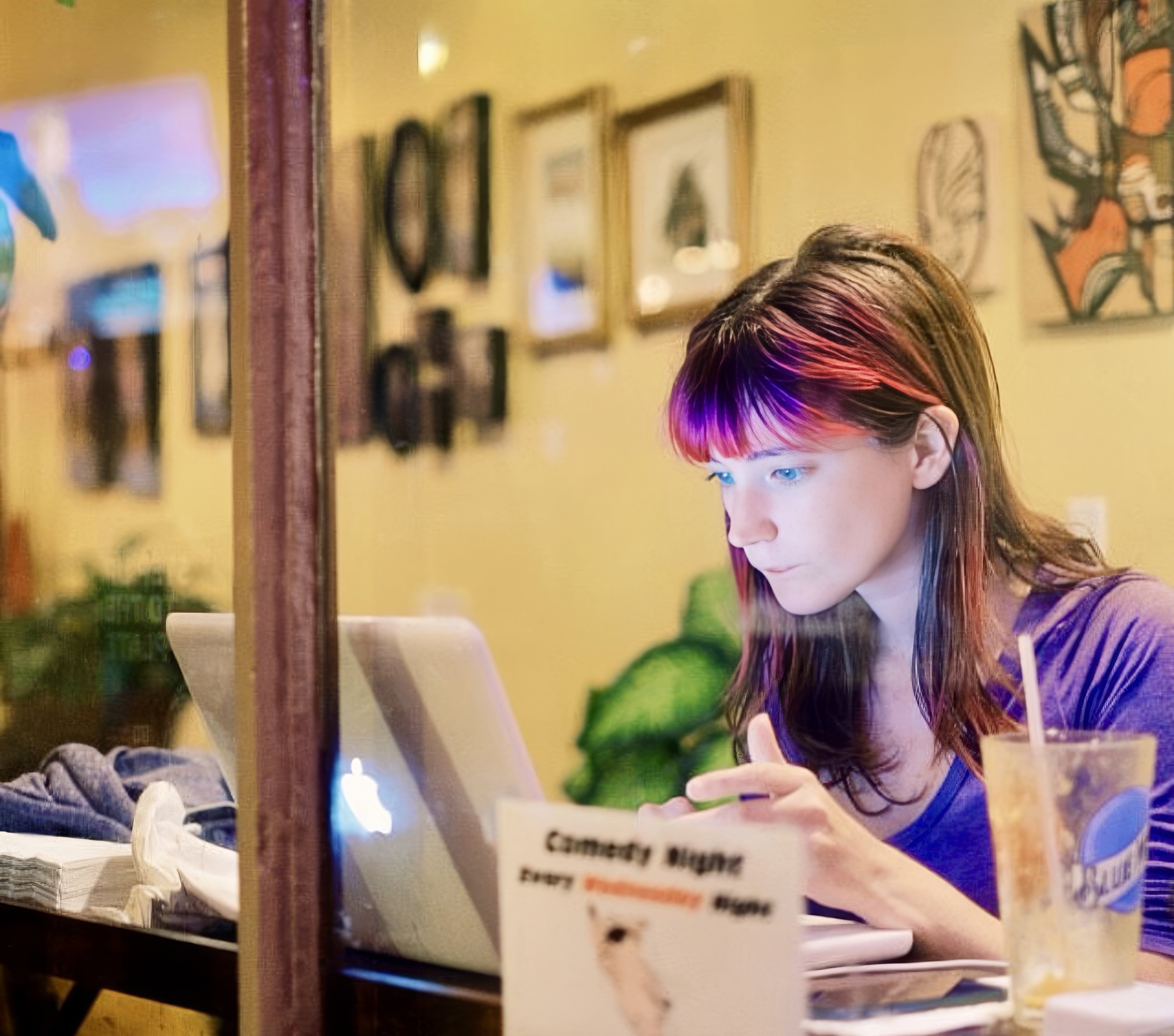 a woman sitting at a table with a laptop