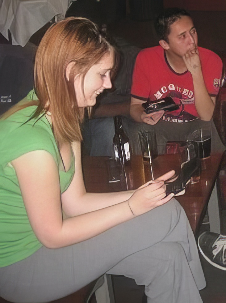 a woman sitting at a table with a cellphone