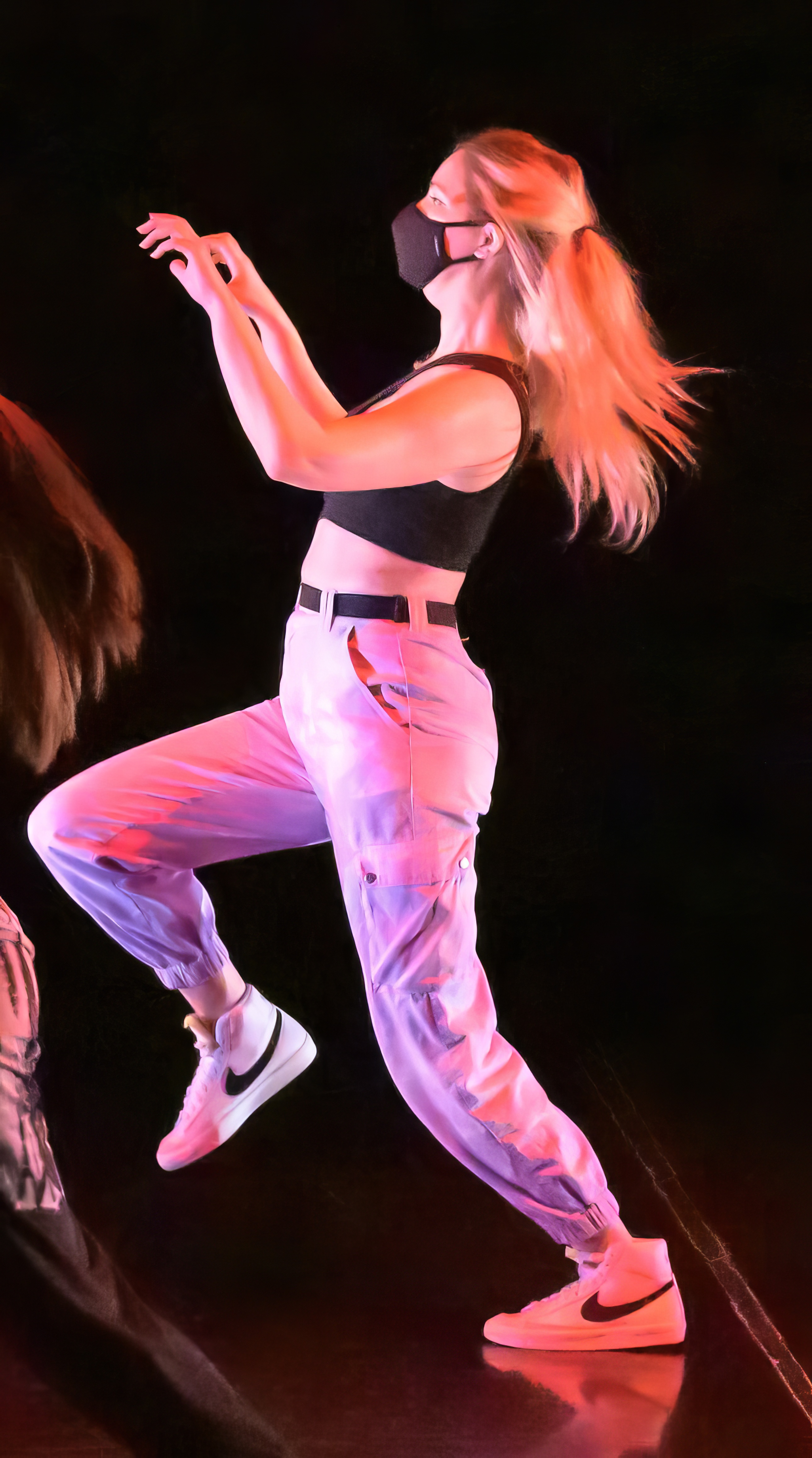 a woman in a black top and white pants