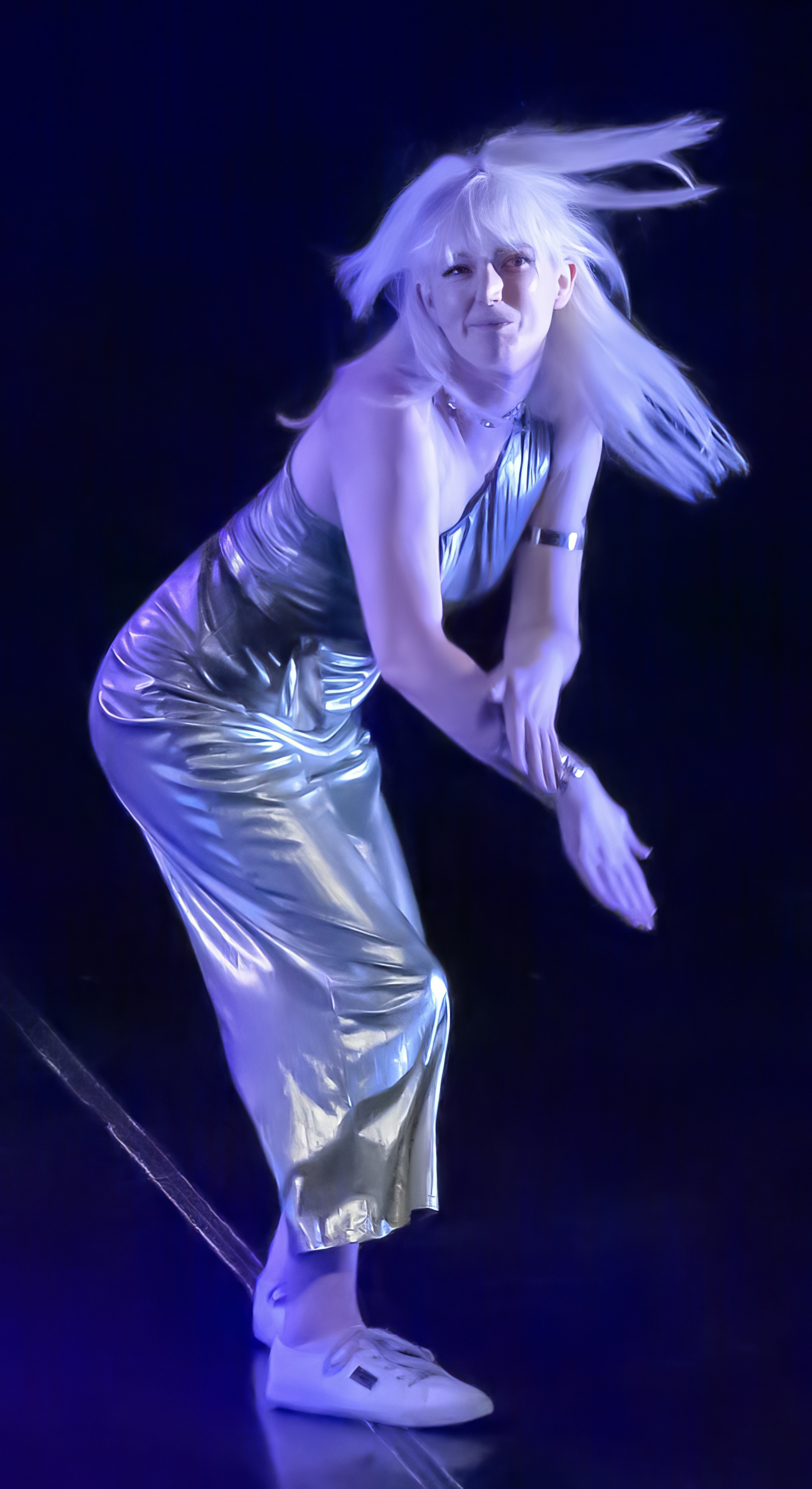 a woman in a silver dress is performing